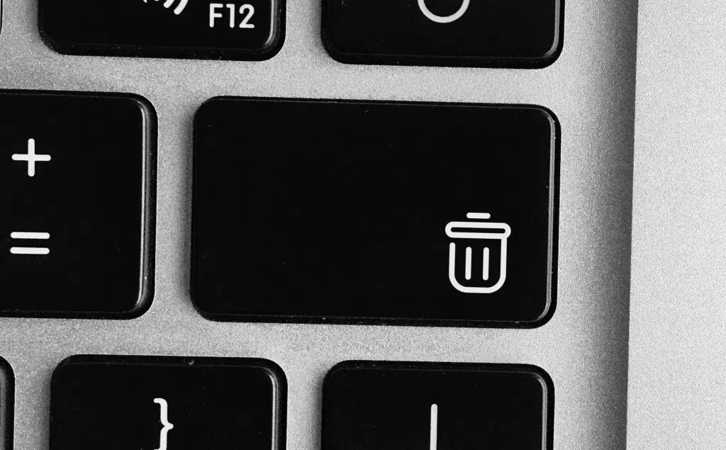 Zoomed in top view of a laptop keyboard, focusing on a 'delete' button.