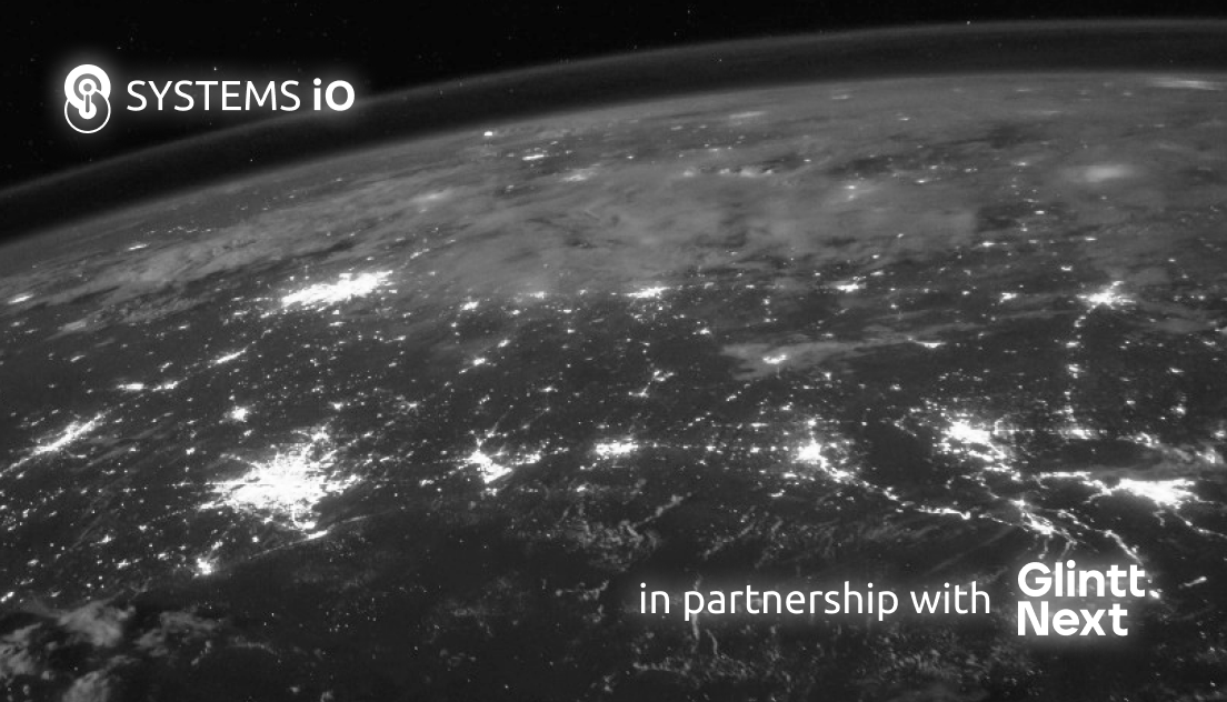 The world as seen from space, in black and white, with cities lit up at night and the Systems iO logo and Glintt Next's logo