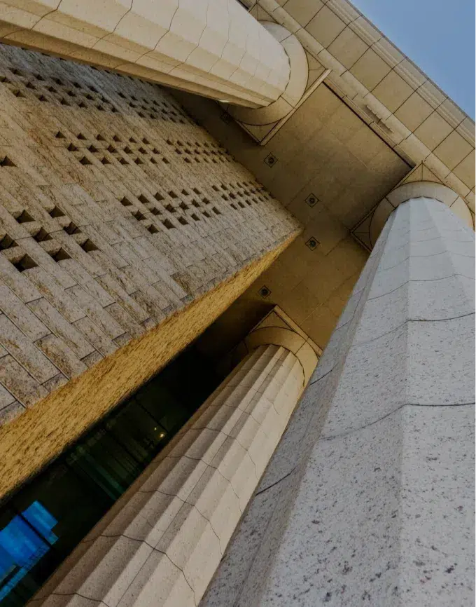 Ground-level view looking up at a government building with tall pillars.