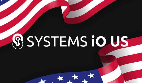 The 'Systems iO' logo with an added 'US' as a suffix in front of two waving American flags.