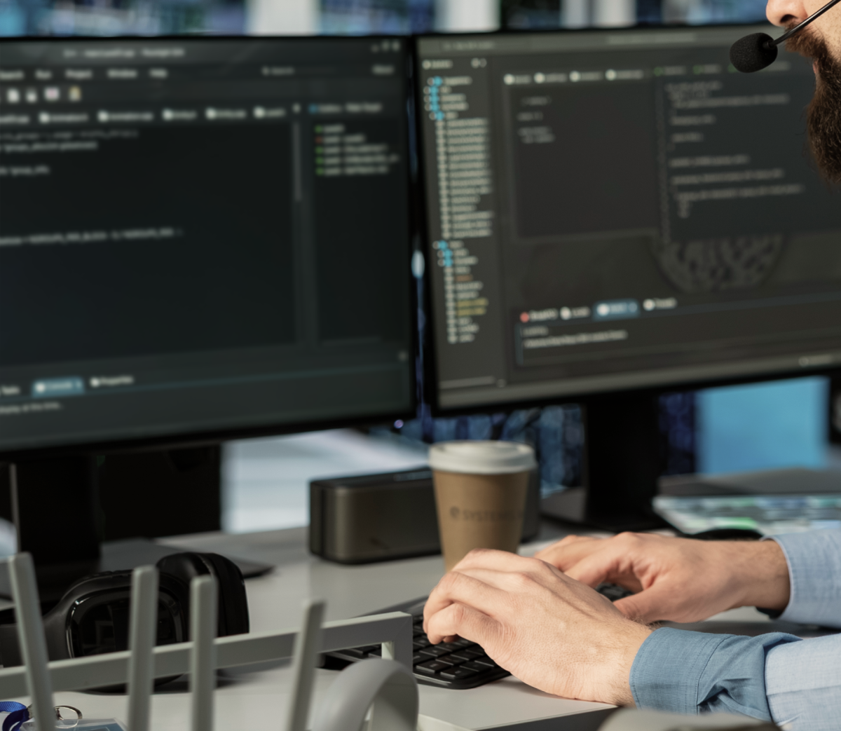 Man with headset doing tech support at a computer.